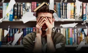 Studente sopraffatto tra libri e lettere volanti, riflette le sfide dell'università e degli sbocchi lavorativi.
