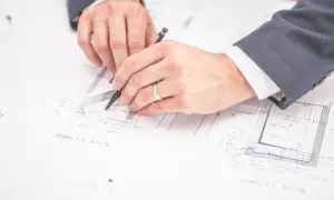 Un ingegnere edile cosa fa? Disegna progetti con righello e matita, pianificando dettagli costruttivi su fogli tecnici.