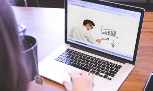 Uomo disegna grafico su schermo laptop, mostrando come le fabbriche che danno lavoro a casa possono far crescere un'idea.
