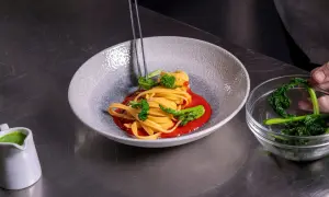 Impiattamento di pasta con broccoli e salsa rossa. La cura nei dettagli mostra come si diventa chef.