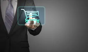 Un uomo in giacca e cravatta preme un carrello della spesa virtuale, mostrando cosa fa un buyer nell'era digitale.