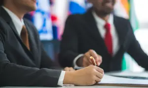 Un diplomatico firma un accordo, un gesto che definisce cosa fa un diplomatico: costruire ponti tra nazioni.