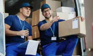 Due fattorini discutono di un pacco, forse valutando il loro stipendio da supply chain manager.