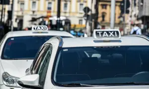 Tassisti in attesa, chissà quanto guadagna un tassista in questa città. Auto bianche con insegna TAXI.