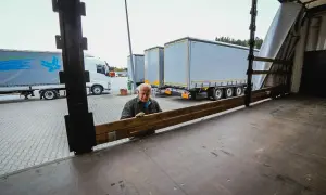 Un camionista internazionale prepara il carico, pensando a quanto guadagna un camionista internazionale.