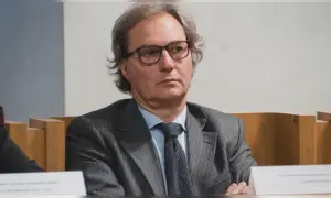 Uomo con occhiali, abito gessato e cravatta scura. Un procuratore cosa fa? Si occupa di giustizia e indagini.