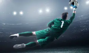 Portiere in tuffo aereo, con la palla in mano, numero 1 sulla maglia. Un'azione decisiva che vale più di uno stipendio portiere senza alloggio.
