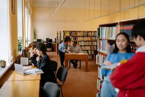 Studenti studiano in biblioteca, un ambiente ideale per chi cerca le psicologia migliori università.