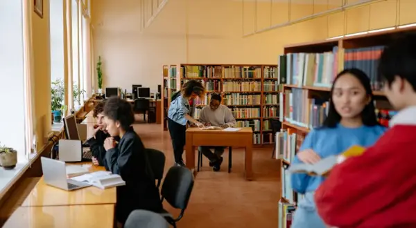 Studenti studiano in biblioteca, un ambiente ideale per chi cerca le psicologia migliori università.
