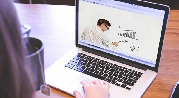 Uomo disegna grafico su schermo laptop, mostrando come le fabbriche che danno lavoro a casa possono far crescere un'idea.