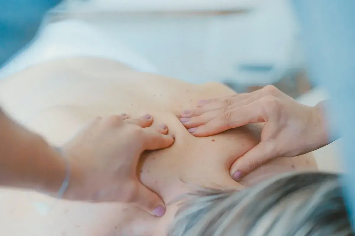 Mani esperte lavorano sulla schiena di un paziente. Un osteopata professionista, con un buon guadagno, offre sollievo.