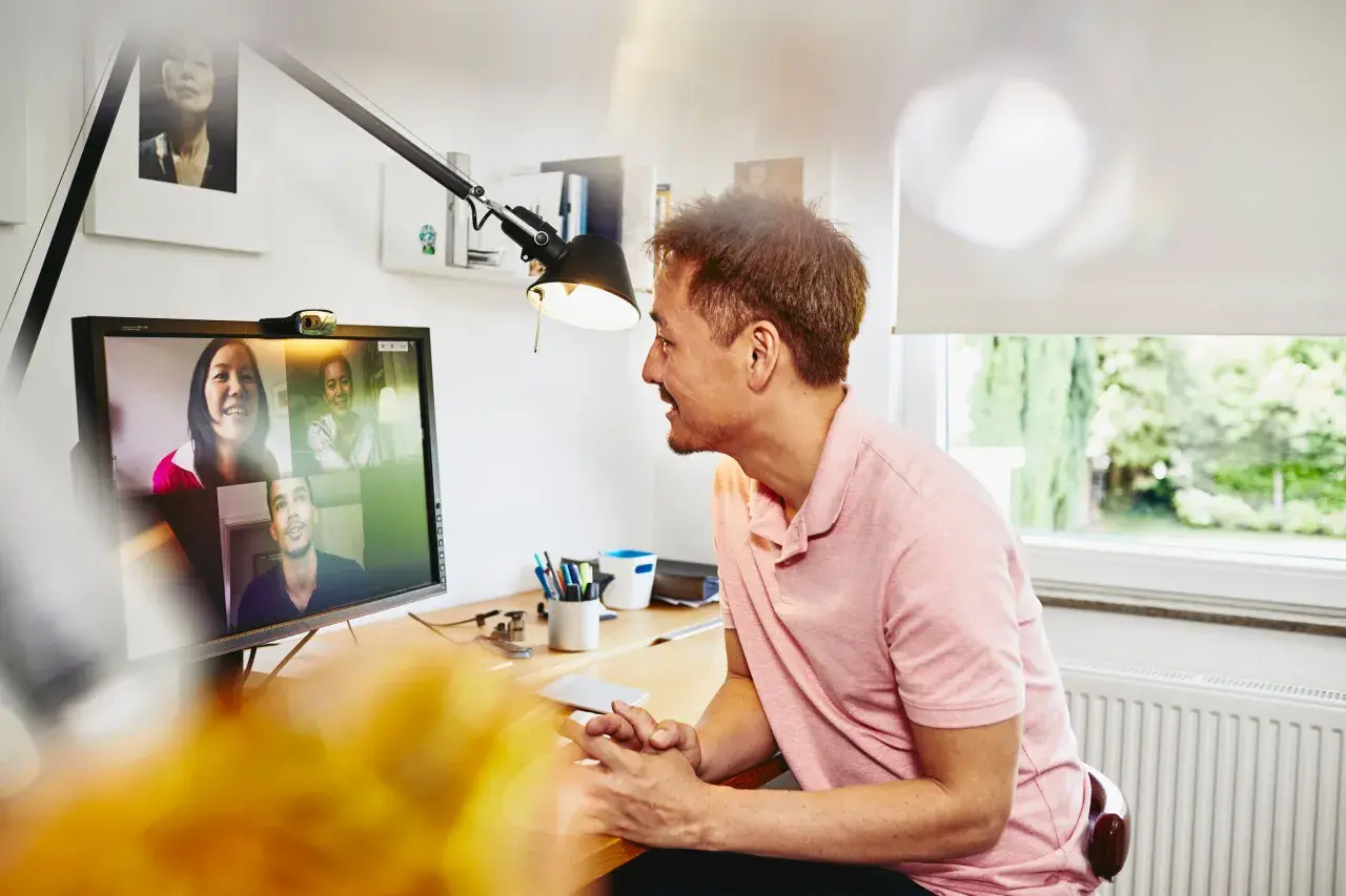 Uomo in videochiamata con colleghi, un esempio di remote jobs Italy.