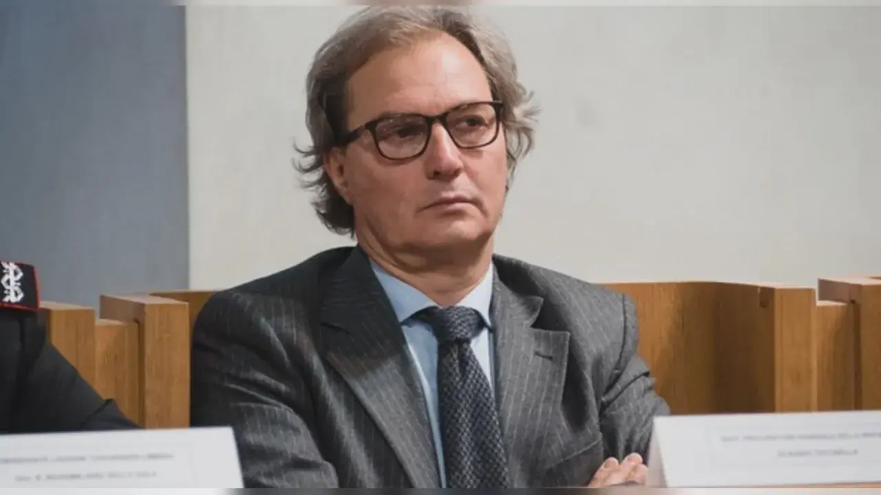 Uomo con occhiali, abito gessato e cravatta scura. Un procuratore cosa fa? Si occupa di giustizia e indagini.