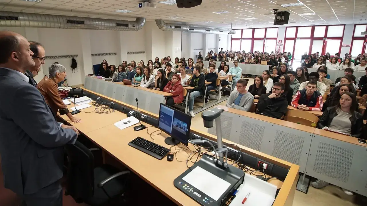 Aula gremita di studenti in un'università, forse la migliore università di giurisprudenza in Italia, ascoltano attentamente un docente.