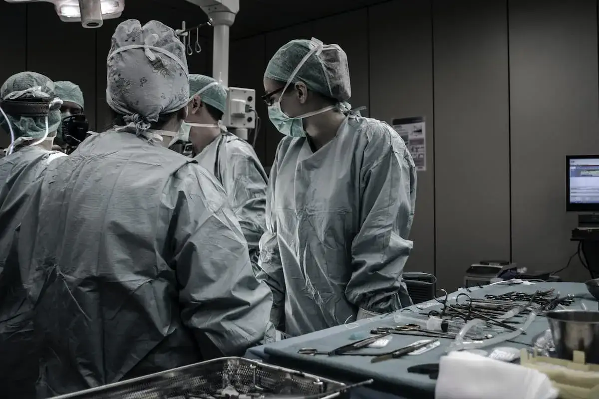 Chirurghi in sala operatoria discutono. Quanto guadagna un medico legale? La risposta &egrave; complessa, ma la dedizione &egrave; alta.