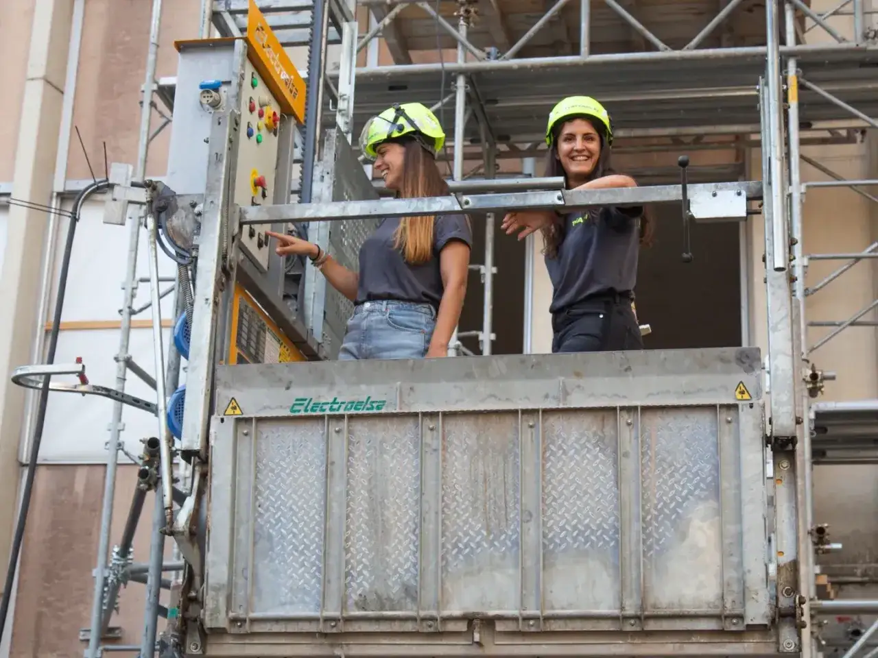 Due ingegneri civili, con caschi gialli, su un cantiere, discutono del progetto.