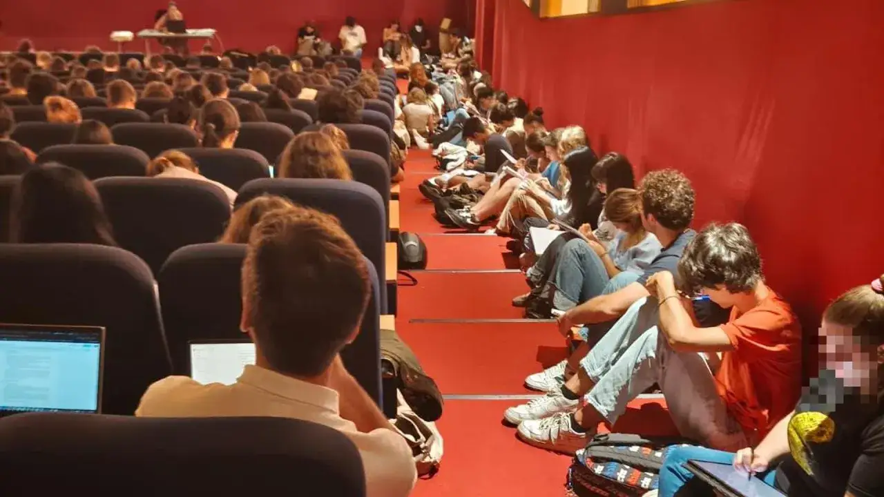 Studenti seduti a terra e in platea, intenti a studiare per la loro psicologia laurea online.