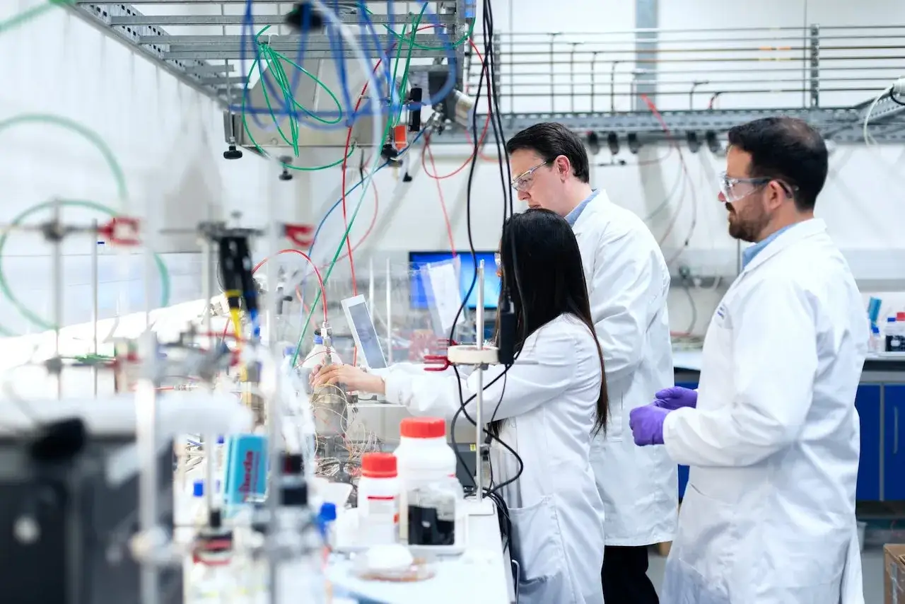 Ingegneri biomedici lavorano in laboratorio con apparecchiature complesse, tubi e monitor.