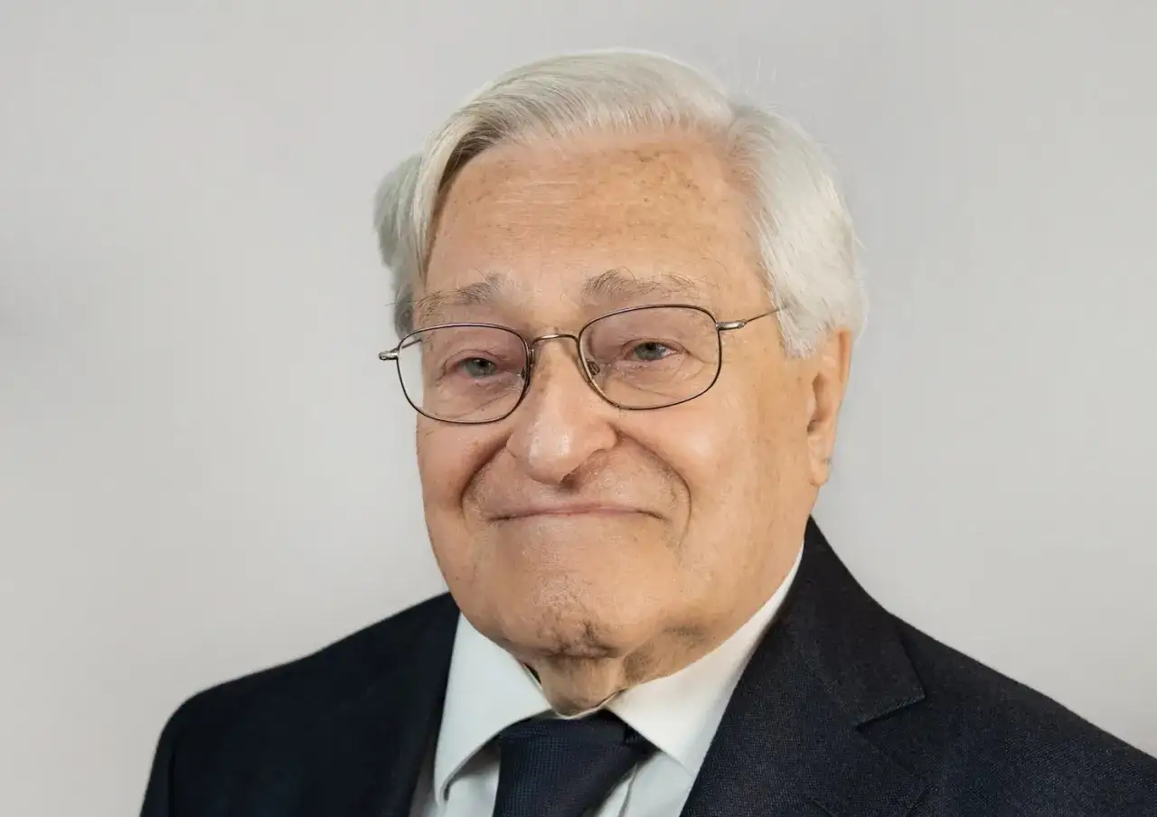 Un uomo anziano con occhiali e abito scuro, un esempio di chi ha deciso di diventare avvocato a 50 anni, dimostrando che non &egrave; mai troppo tardi per realizzare i propri sogni.