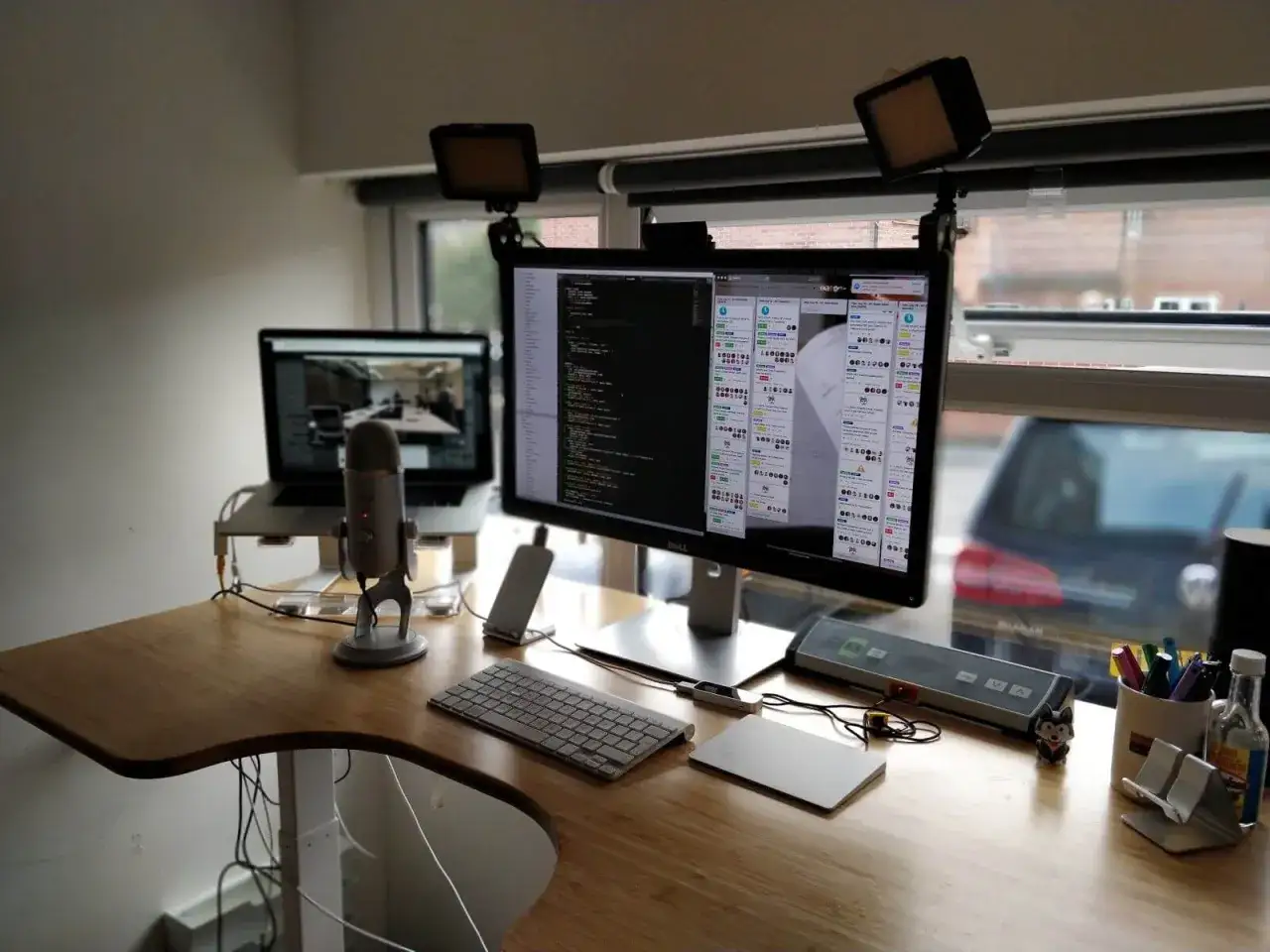 Postazione per work from home jobs: doppio monitor, laptop, microfono, luci e tastiera. Ideale per chi lavora da casa.
