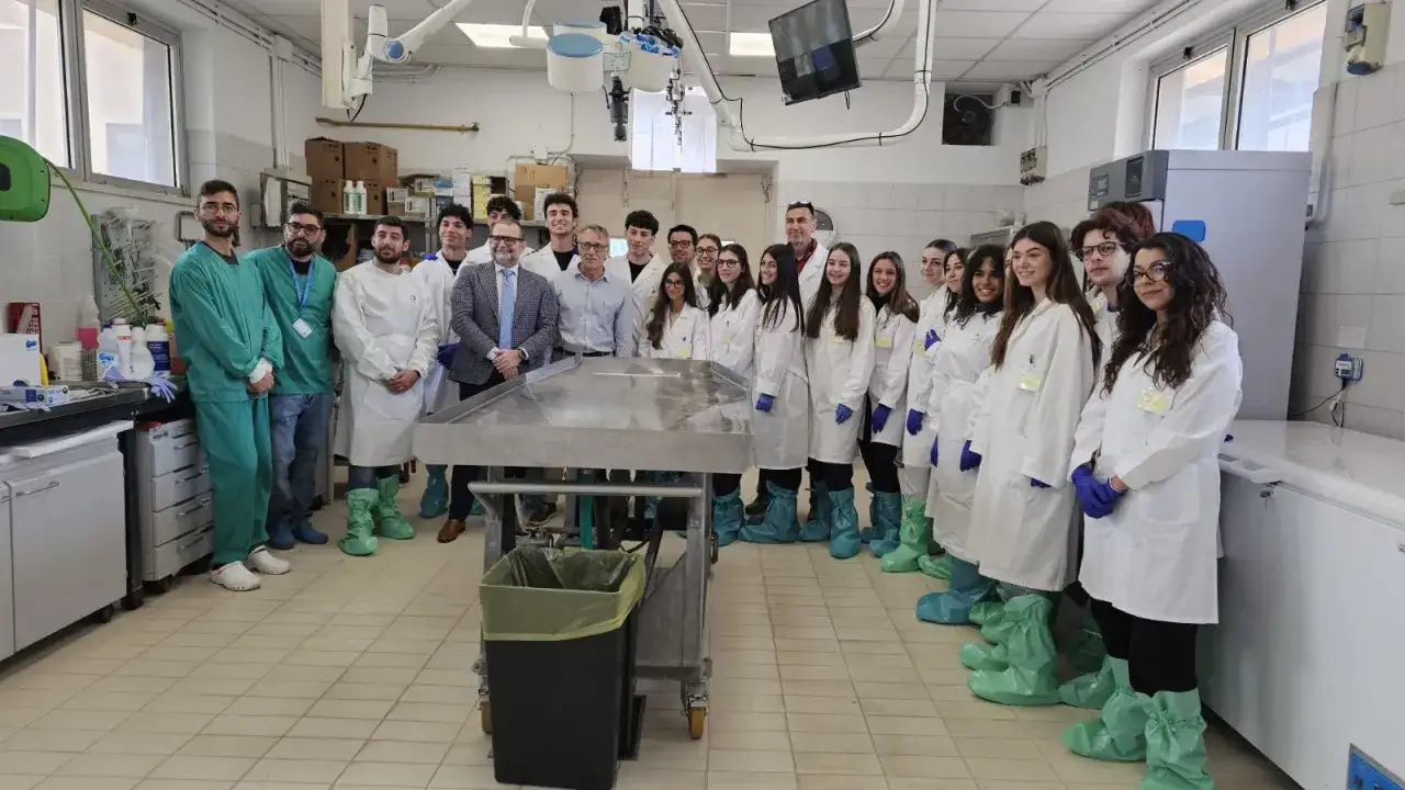 Gruppo di studenti e docenti in camice in un laboratorio, un passo importante per capire come diventare veterinario.