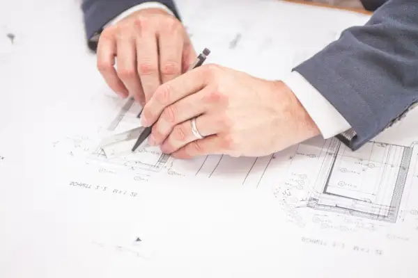 Un ingegnere edile cosa fa? Disegna progetti con righello e matita, pianificando dettagli costruttivi su fogli tecnici.