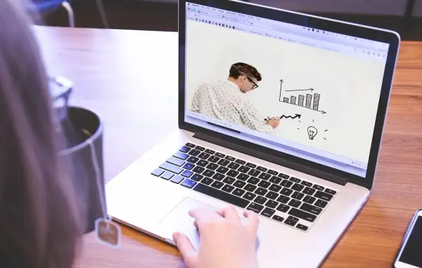 Uomo disegna grafico su schermo laptop, mostrando come le fabbriche che danno lavoro a casa possono far crescere un'idea.