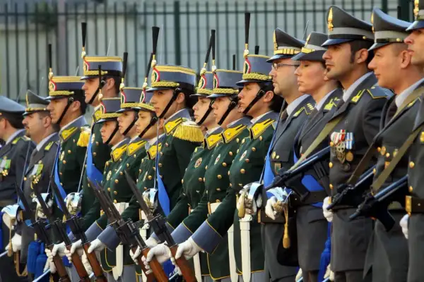 Uomini e donne in uniforme, con fucili, pronti a servire. Un'immagine che ispira a capire come diventare finanziere.