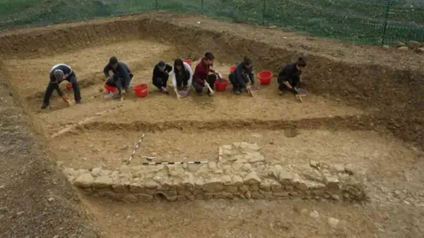Archeologi scavano con cura, scoprendo antiche rovine. Chissà quanto guadagna un archeologo per un lavoro così affascinante e faticoso!