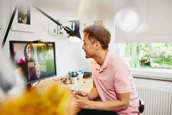 Uomo in videochiamata con colleghi, un esempio di remote jobs Italy.