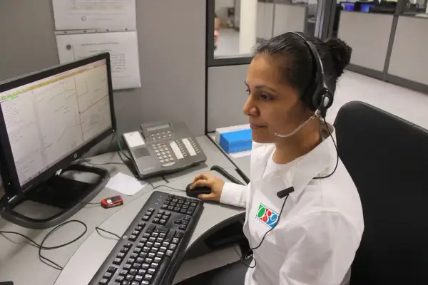 Operatrice al centro di controllo, forse per offerte lavoro cup strutture sanitarie, con cuffie e microfono, davanti a un computer con mappa.
